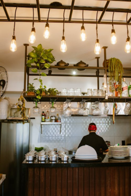 Chef working behind a restaurant counter, preparing food and drinks for customers
