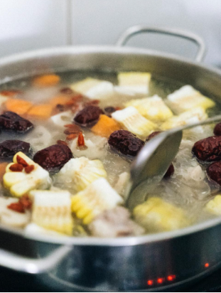 This image shows soup in a pot with different ingredients