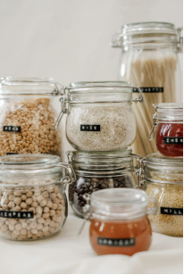 This photo shows labeled jars of grains, rice flour and spices