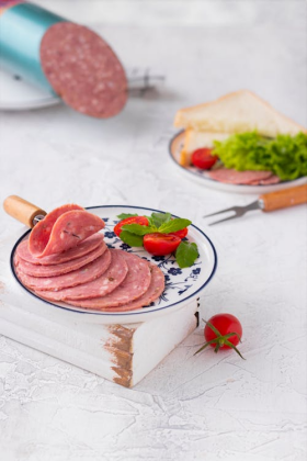 Sliced salami sandwich with fresh vegetables, ready for serving in a restaurant or deli setting