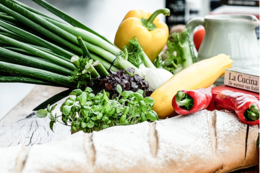 Fresh vegetables and artisanal bread on a wooden table, ready for use in restaurant menu preparations and seasonal dishes.